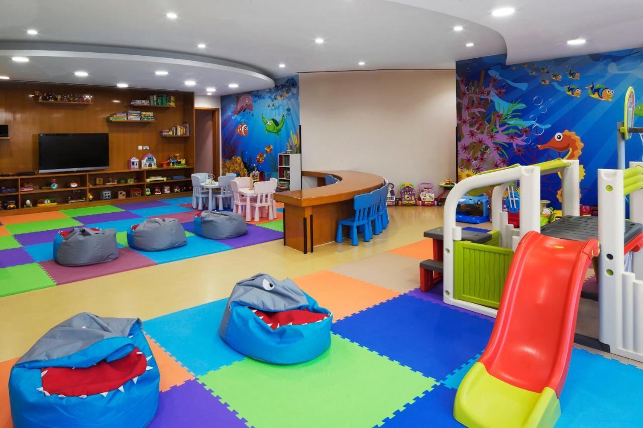 Dukes The Palm, A Royal Hideaway Hotel Dubai Exterior photo The photo shows a colorful children's playroom designed for fun and engagement. The flooring has various colored mats, creating a vibrant and safe environment for kids. 

In the center, there are several bean bags shaped like sharks, adding a playful