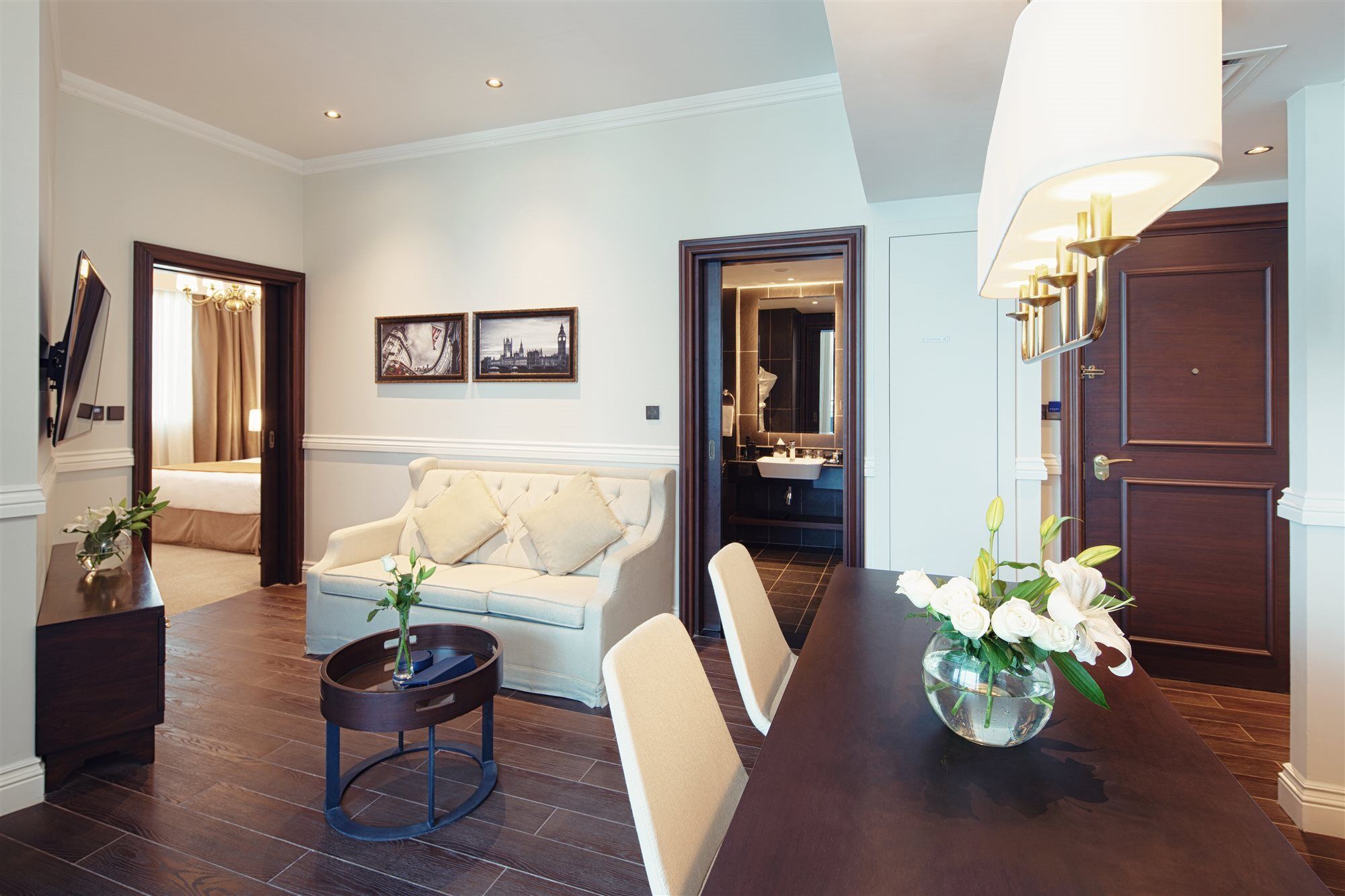 Dukes The Palm, A Royal Hideaway Hotel Dubai Exterior photo The photo shows a stylish hotel suite or living area. You can see a comfortable light-colored sofa with decorative cushions, positioned next to a small round coffee table. There are two framed artworks on the wall, adding a touch of decor. Directly a